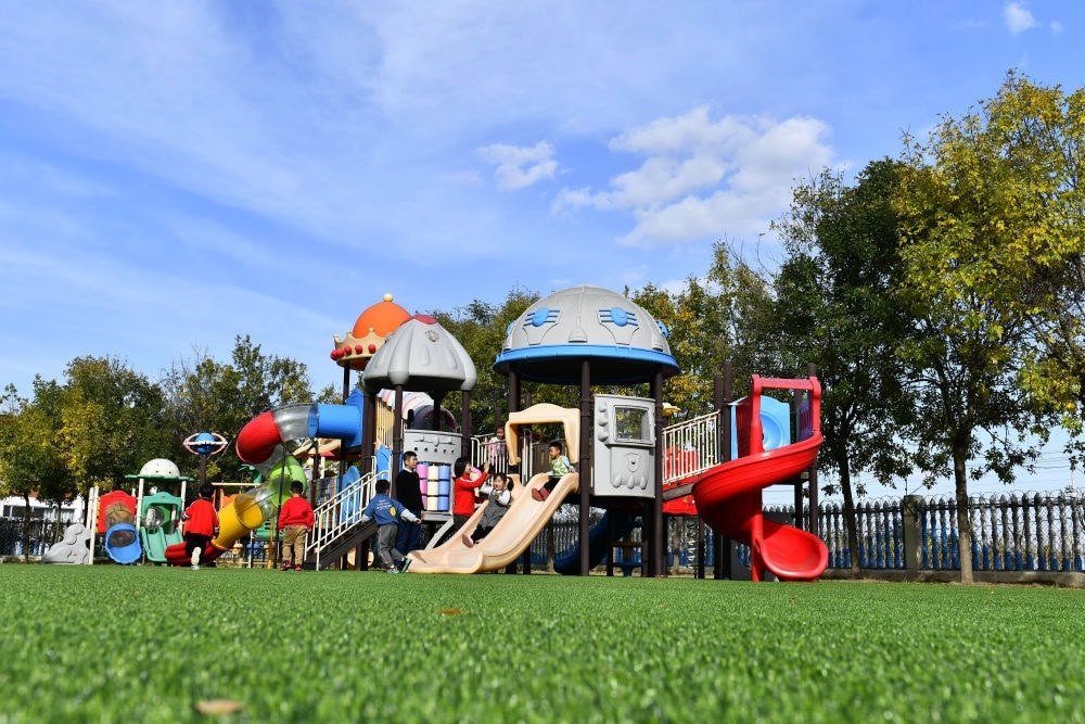 在山東省東營市墾利區(qū)楊廟社區(qū)幼兒園，孩子們在老師的帶領下進行戶外活動（2021年10月19日攝）。新華社記者 郭緒雷 攝