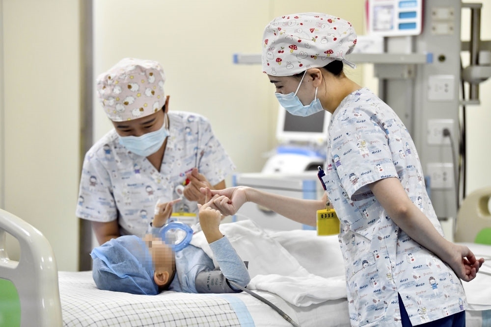 在山東省棗莊市婦幼保健院兒童ICU病房，醫(yī)護(hù)人員為完成靶向治療藥物諾西那生鈉的4歲脊髓性肌萎縮癥患兒加油鼓勁（2022年1月1日攝）。諾西那生鈉注射液是我國首個(gè)獲批治療脊髓性肌萎縮癥的進(jìn)口藥物，2019年進(jìn)入中國市場時(shí)，每針價(jià)格近70萬元。在2021年國家醫(yī)保目錄藥品談判中，以3.3萬元每針的價(jià)格進(jìn)入新版醫(yī)保藥品目錄。新華社記者 郭緒雷 攝