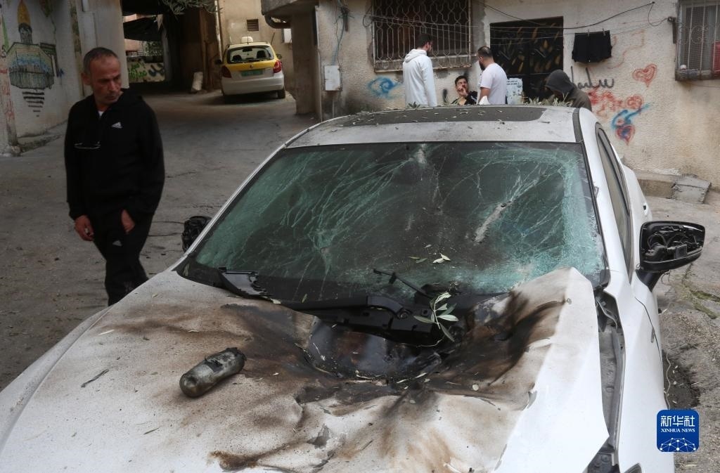 12月17日，在約旦河西岸城市圖勒凱爾姆附近的一處難民營(yíng)，人們查看在沖突中損毀的車輛。新華社發(fā)（尼達(dá)爾·艾仕塔耶?dāng)z）