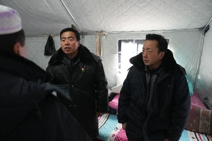 2023年12月22日，積石山縣大河家鎮(zhèn)大河村黨支部書記馬成忠（右二）在帳篷里和受災(zāi)群眾交流。新華社記者 陳斌 攝