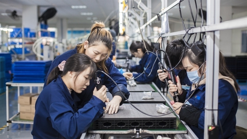 在新亞勝光電的產(chǎn)品線上，工人正進行產(chǎn)品組建和安裝布線。受訪者供圖