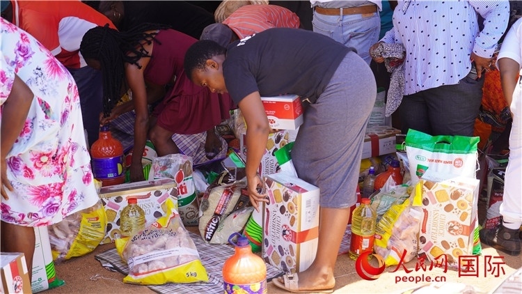 當?shù)厣鐓^(qū)家庭領(lǐng)取物資。人民網(wǎng) 張茜攝