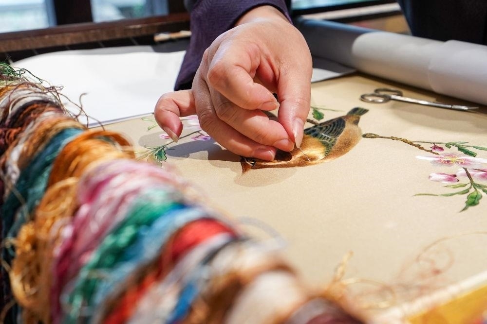 △2023年7月6日，盧建英在江蘇蘇州平江路的工作室內(nèi)刺繡。