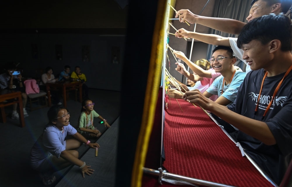 2023年8月8日，進(jìn)行暑期研學(xué)的學(xué)生在位于陜西省西安市的中國秦腔藝術(shù)博物館體驗(yàn)皮影戲演出。新華社記者 鄒競一 攝