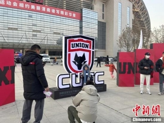 球迷們與隊(duì)徽合影。記者 卞立群 攝