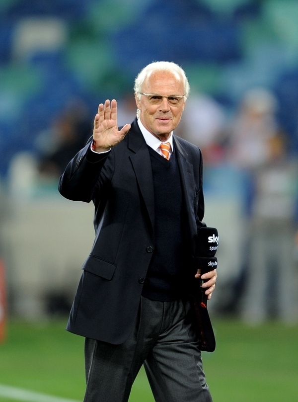 這是2010年7月7日，在南非德班舉行的2010年足球世界杯德國隊對陣西班牙隊的半決賽前，貝肯鮑爾接受電視臺采訪時和友人打招呼。新華社記者 王毓國 攝