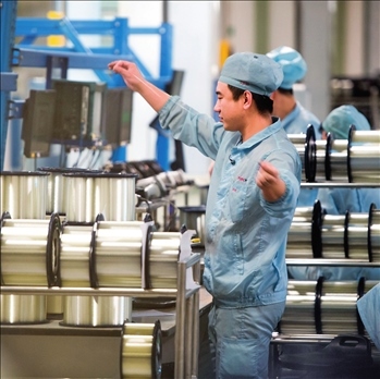 在位于武漢的長飛光纖光纜股份有限公司光纖生產(chǎn)車間內(nèi)，工作人員對光纖進(jìn)行檢測（資料圖片）。肖藝九攝/本刊