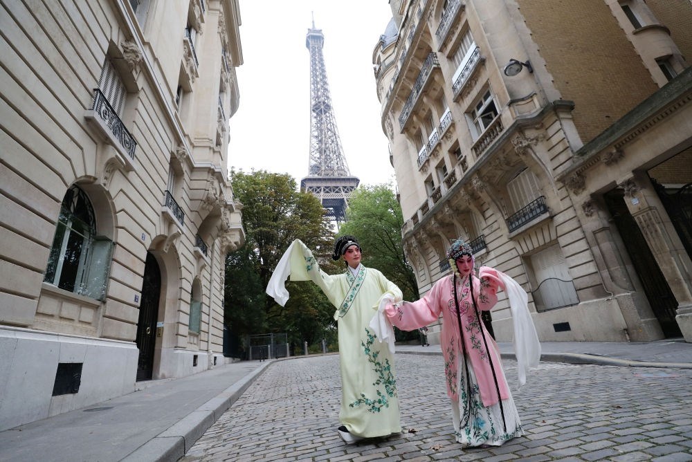 2023年9月13日，江蘇省演藝集團(tuán)昆劇院院長施夏明（左）和江蘇省演藝集團(tuán)昆劇院國家一級演員孔愛萍在法國巴黎埃菲爾鐵塔附近參加昆曲快閃。新華社記者 高靜 攝