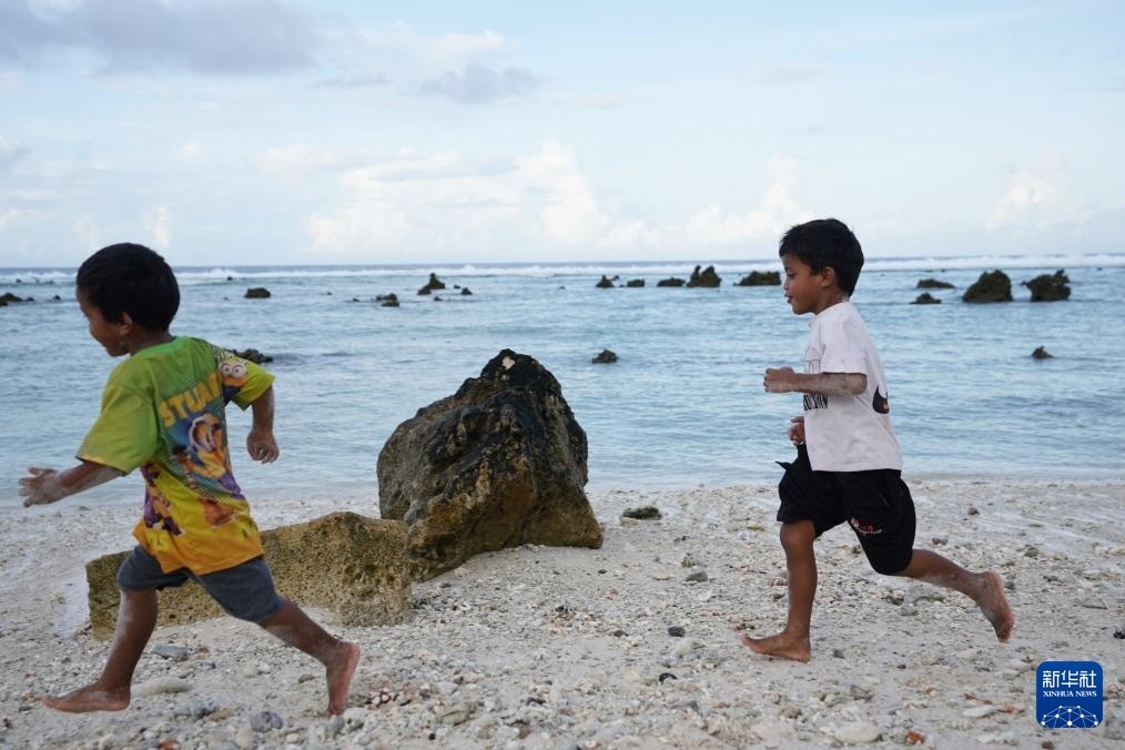 1月20日，兒童在瑙魯海邊嬉戲。新華社記者 王申 攝