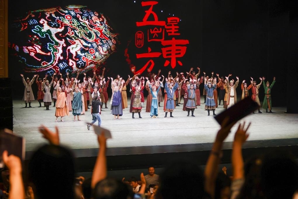 2023年7月31日，新疆和田地區(qū)新玉歌舞團(tuán)在烏魯木齊京劇院演出舞劇《五星出東方》后和觀眾互相揮手致意。這場(chǎng)演出是第六屆中國(guó)新疆國(guó)際民族舞蹈節(jié)的參演劇目之一，曾榮獲國(guó)家“文華獎(jiǎng)”等。新華社記者 郝昭 攝