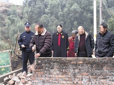  圖③：庭審結(jié)束后，在法官的見證下，陳某在院壩邊重新開鑿一條通道。