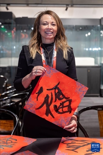 1月28日，在上海豫園舉行的民俗活動上，美國馬斯卡廷初中校長珍妮弗·李·弗里德利展示自己寫下的“?！弊?。 新華社記者 王翔 攝