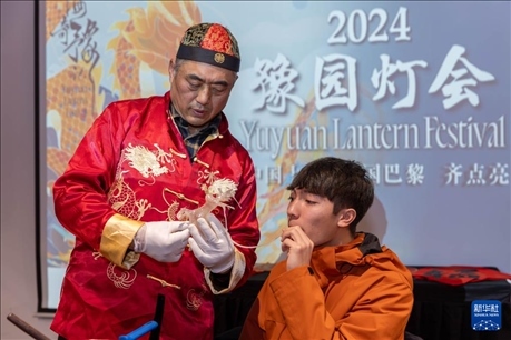 1月28日，在上海豫園舉行的民俗活動上，美國馬斯卡廷中學(xué)學(xué)生在非遺傳承人的指導(dǎo)下吹糖偶。 新華社記者 王翔 攝