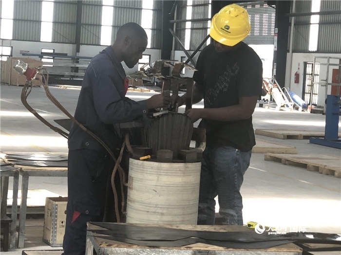 經(jīng)貿(mào)合作區(qū)廠房內(nèi)，當?shù)毓と苏诰o張作業(yè)。人民網(wǎng)記者 黃培昭攝