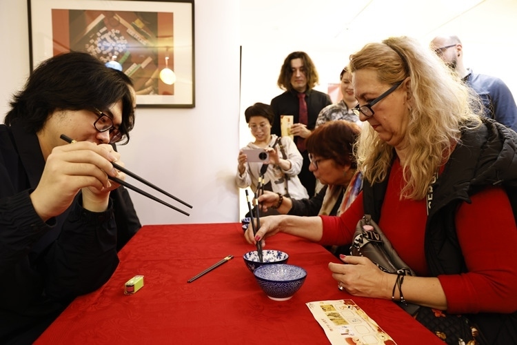 羅馬尼亞觀眾體驗用筷子夾花生。中國文化中心供圖