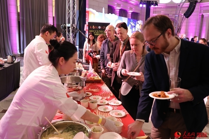 當(dāng)?shù)貢r間3月7日晚，華盛頓聯(lián)合車站廣場舉行駐美使團(tuán)“使館主廚挑戰(zhàn)賽”。圖為當(dāng)?shù)孛癖娫谥袊古_前體驗(yàn)中國美食。人民網(wǎng)記者 李志偉攝