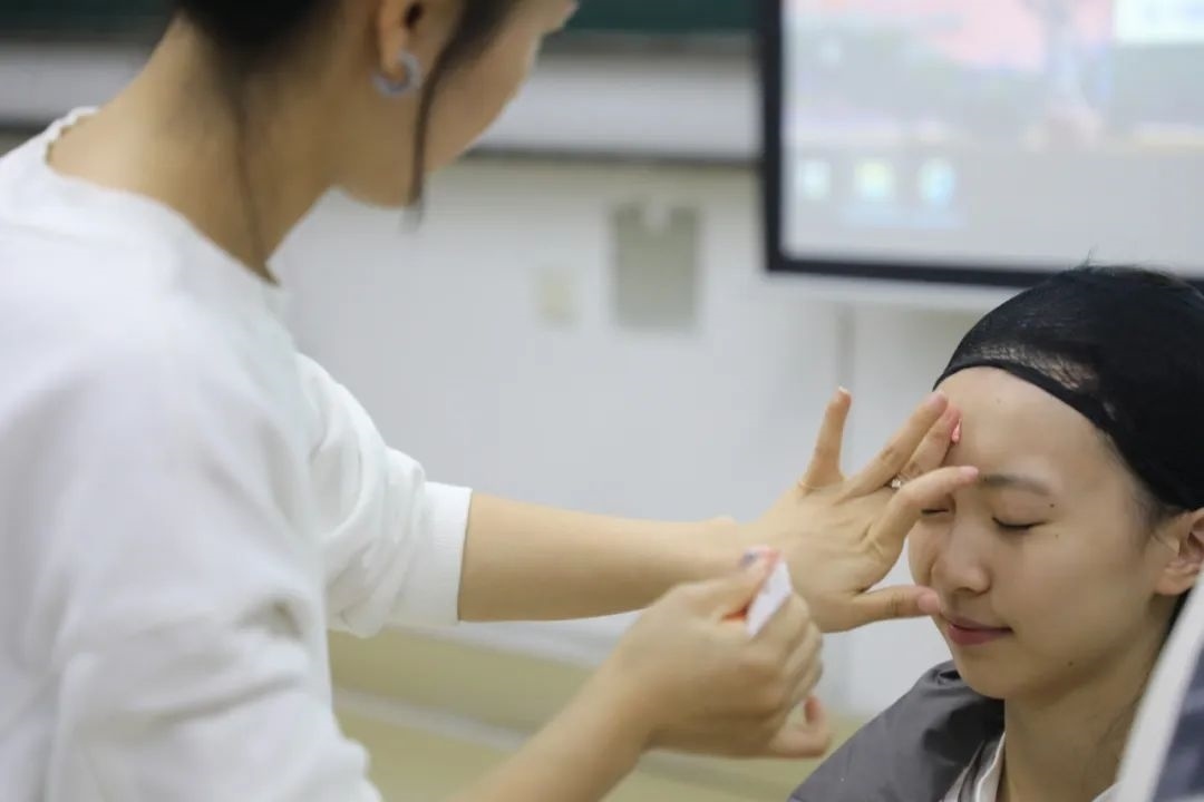 課堂上，一名學(xué)生在體驗上戲妝。學(xué)校供圖