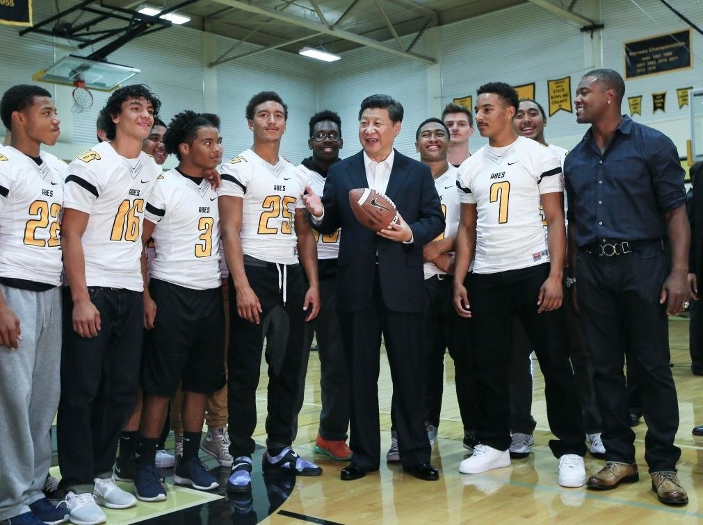 2015年9月23日，國家主席習(xí)近平參觀美國塔科馬市林肯中學(xué)。這是習(xí)近平在學(xué)校體育館，同上橄欖球訓(xùn)練課的學(xué)生們親切交談。新華社記者 蘭紅光 攝