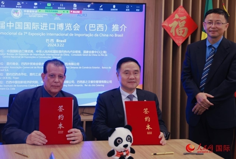 巴西外貿(mào)商會(huì)聯(lián)合會(huì)會(huì)長(zhǎng)阿代爾·羅伯托（左）與中國(guó)國(guó)際進(jìn)口博覽局副局長(zhǎng)吳政平（中）現(xiàn)場(chǎng)簽訂協(xié)議。人民網(wǎng)記者 宋亦然攝