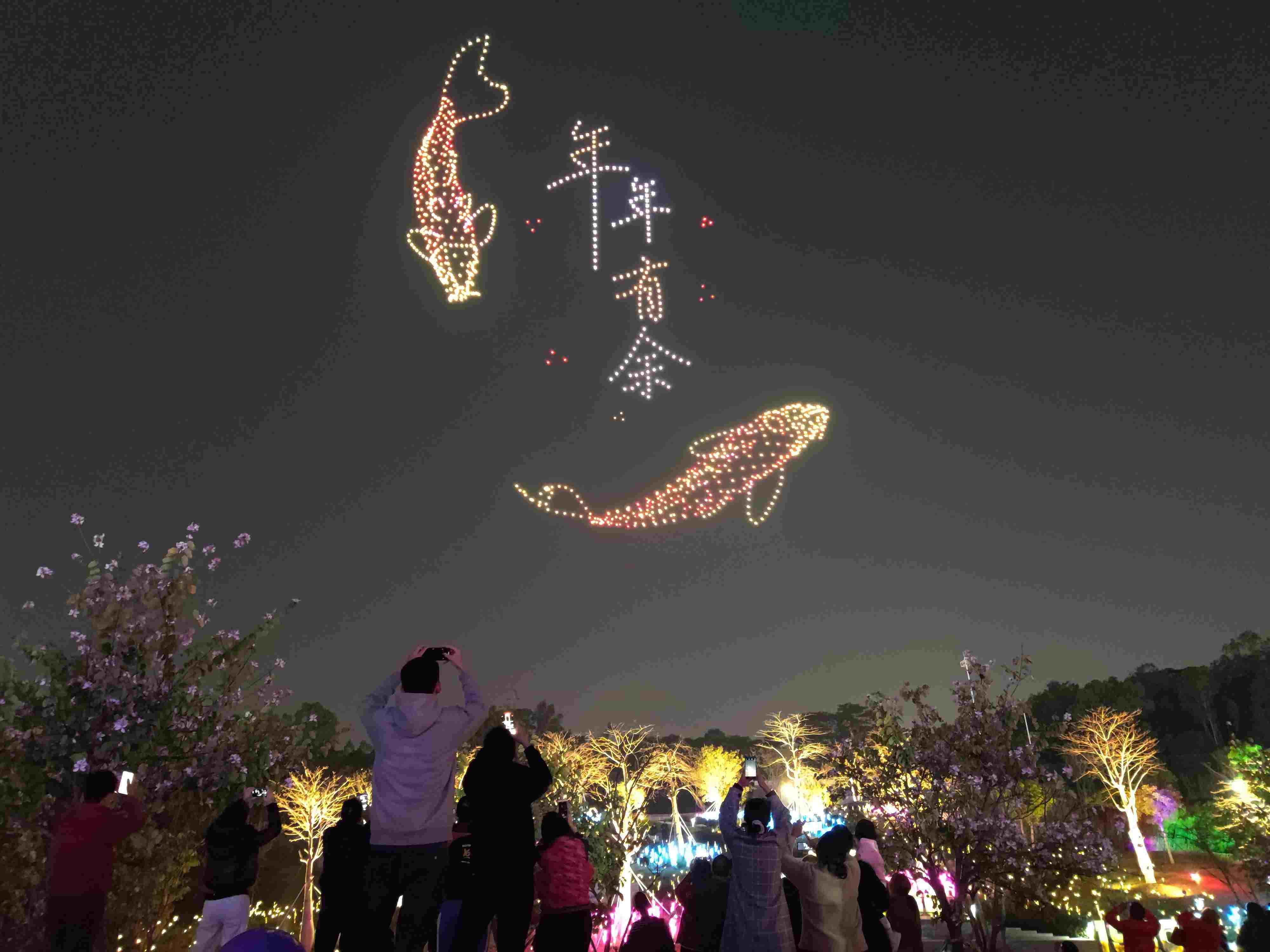 △ 2024年2月10日，深圳北站中心公園，春節(jié)主題無人機(jī)燈光秀引來眾多游客駐足觀看。