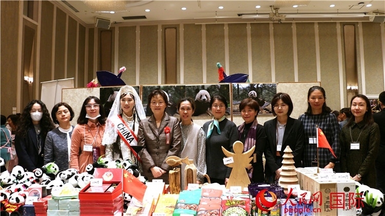 中國駐日本大使吳江浩夫人丁玥（左五）與使館人員在展位前合影留念。人民網(wǎng) 許可攝