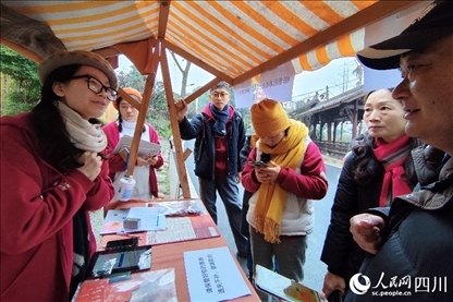 1月6日，“2024成都蒲江柑甜采摘節(jié)”上，記者見到了小萌（左一）和許多年輕人忙著做訪客接待、現(xiàn)場布置、票務(wù)核對(duì)、采摘服務(wù)等工作。人民網(wǎng)記者朱虹攝