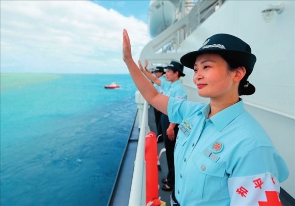 中國(guó)海軍“和平方舟”號(hào)醫(yī)院船結(jié)束訪問湯加時(shí)，任務(wù)官兵中的文職人員向歡送人群揮手告別（2023年8月4日攝）。徐巍攝/本刊