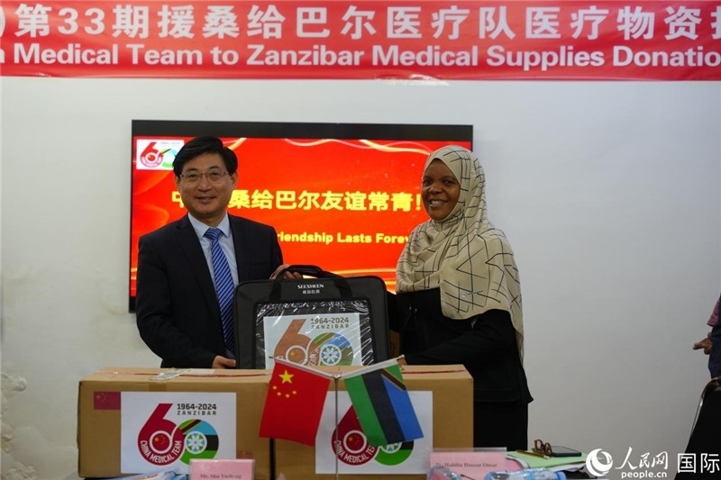 江蘇省蘇北人民醫(yī)院黨委書記束余聲捐贈物資與桑衛(wèi)生部首席秘書哈比巴。中國援桑醫(yī)療隊供圖