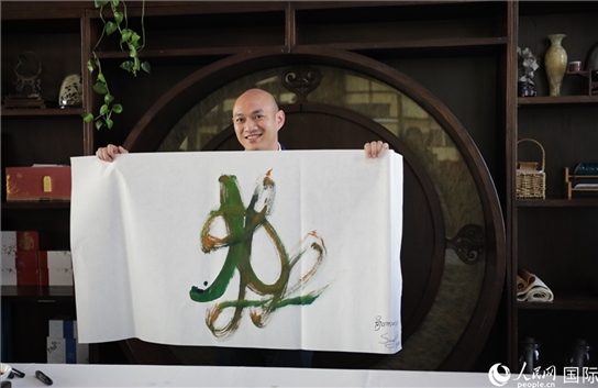 老撾駐華大使館三秘明君參加《五百筆·瀾湄合作》集體藝術(shù)創(chuàng)作。人民網(wǎng)王婧攝。