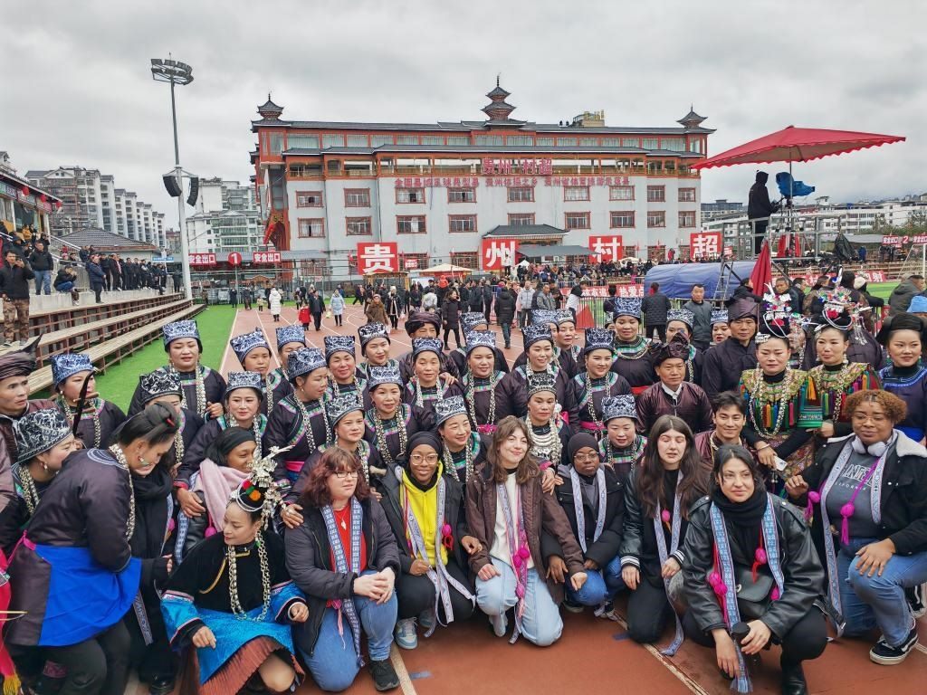 法國青年在“村超”賽場邊與參加表演的村民合影。新華社記者 羅羽 攝