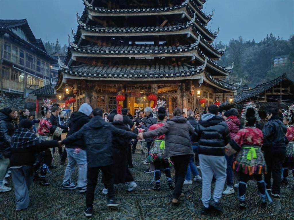 法國青年與當?shù)卮迕駹渴痔?。新華社記者 羅羽 攝