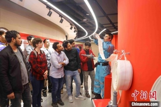 5月9日，工作人員指導(dǎo)留學(xué)生正確使用消防水帶。張鷹 攝