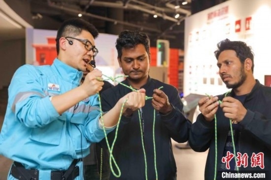 5月9日，工作人員指導(dǎo)留學(xué)生學(xué)習(xí)打繩結(jié)。張鷹 攝