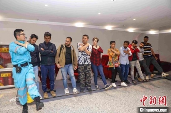 5月9日，工作人員指導(dǎo)留學(xué)生練習(xí)逃生技巧。張鷹 攝