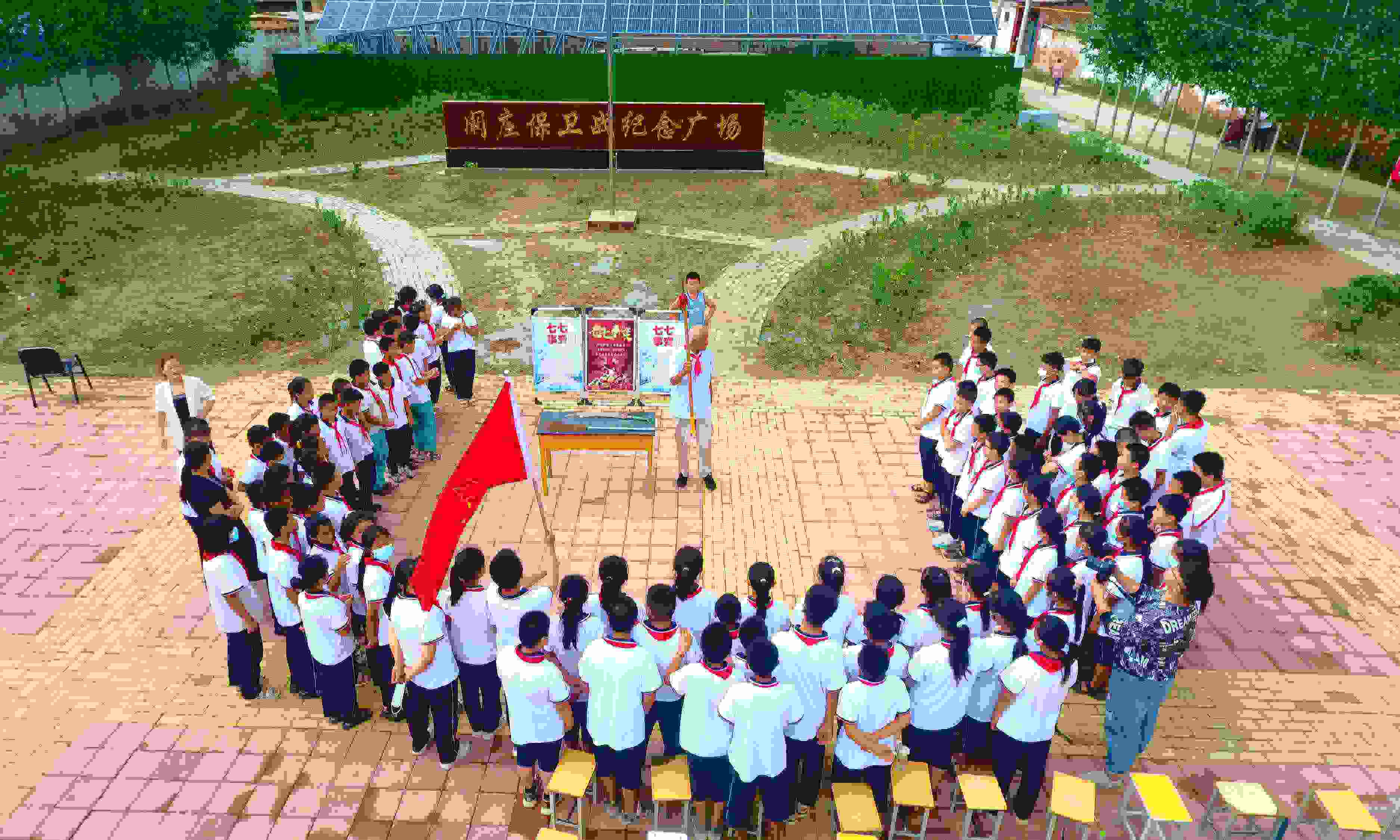 2022年7月6日，山東省聊城市，在茌平區(qū)菜屯鎮(zhèn)闞莊村的闞莊保衛(wèi)戰(zhàn)紀念廣場，闞莊保衛(wèi)戰(zhàn)親歷者王光木老人為小學生們講述抗戰(zhàn)故事，展示大刀、長矛。