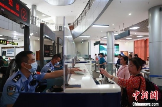 圖為旅客在磨憨口岸辦理通關(guān)手續(xù)。雷雨 攝