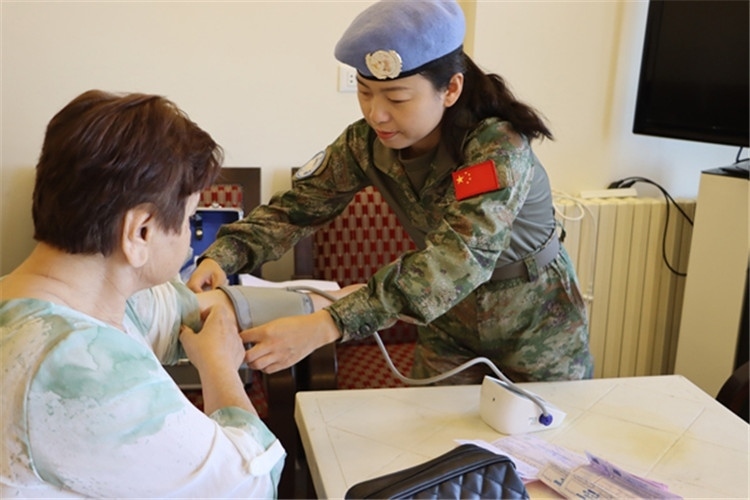 【1】 醫(yī)療分隊隊員為當?shù)鼗颊邷y量血壓。曾德樂攝