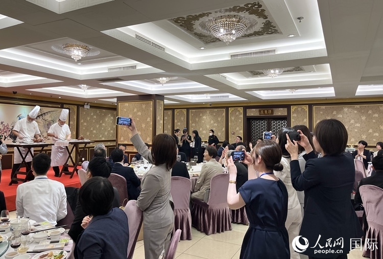 國家級非物質(zhì)文化遺產(chǎn)、全聚德片鴨工藝吸引代表團(tuán)成員拍照留念。