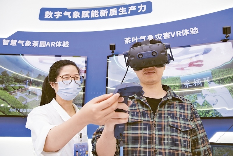 2024年5月23日，第七屆數(shù)字中國建設(shè)峰會現(xiàn)場體驗區(qū)在福州海峽國際會展中心向?qū)I(yè)觀眾開放。本次現(xiàn)場體驗區(qū)圍繞本屆峰會主題“釋放數(shù)據(jù)要素價值，發(fā)展新質(zhì)生產(chǎn)力”，設(shè)置“數(shù)字惠民”、“數(shù)字能力”、“數(shù)字基礎(chǔ)”、“數(shù)字生態(tài)”、“數(shù)字賦能”五大板塊。圖為一名觀眾（右）在數(shù)字氣象賦能新質(zhì)生產(chǎn)力展臺上進行體驗。 新華社記者 魏培全/攝