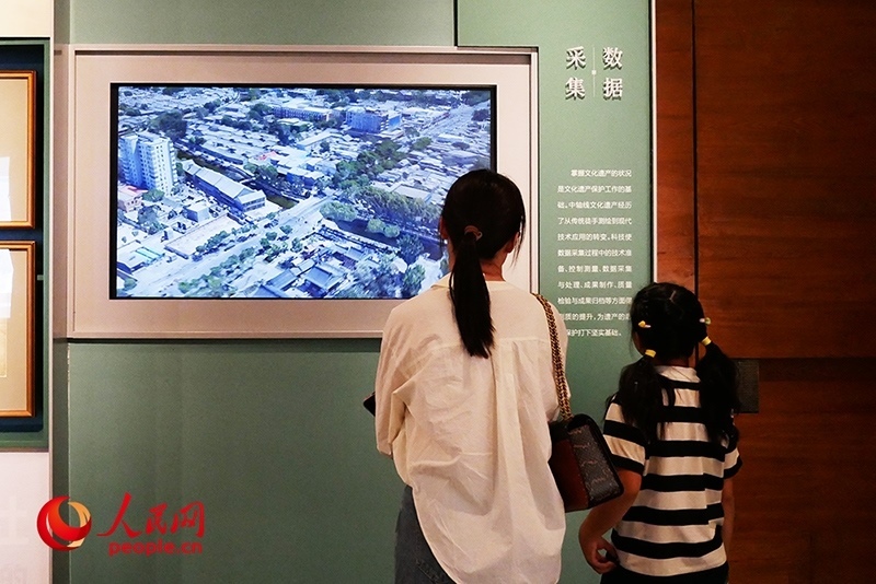 家長正在帶孩子參觀“輝煌中軸”專題展。人民網記者 韋衍行攝