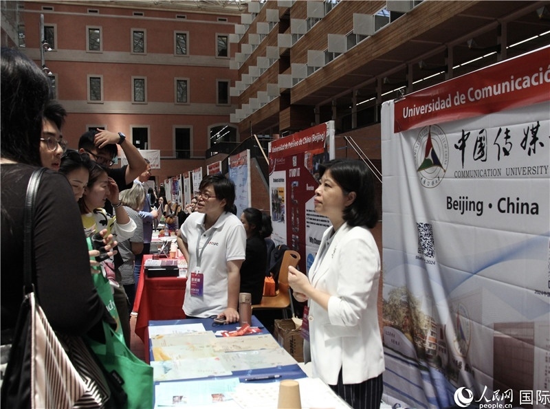 旅西華人華僑在展臺(tái)前咨詢。人民網(wǎng)記者 許海林?jǐn)z