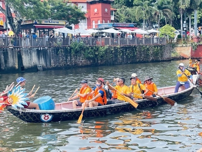 多元種族共同奮輯前進(jìn)，體驗(yàn)在馬六甲河劃龍舟，引來(lái)大批游客駐足圍觀。組委會(huì)供圖