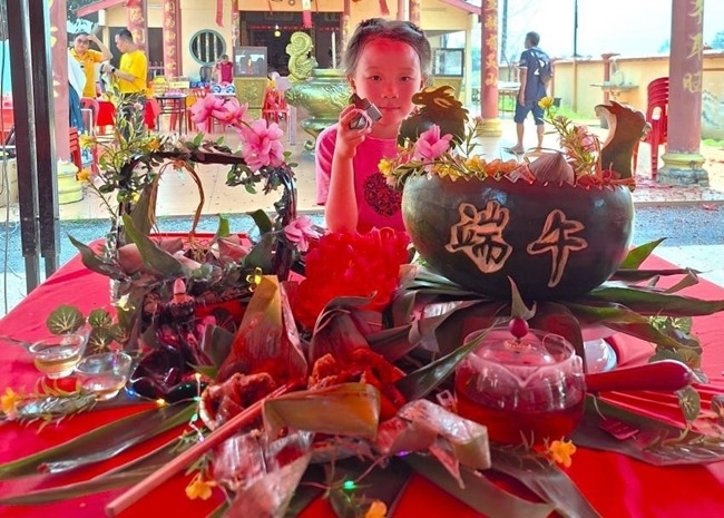 小朋友展示學(xué)裹粽子的成品照。組委會(huì)供圖