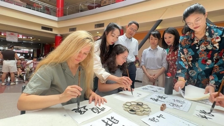 羅馬尼亞友人在活動(dòng)現(xiàn)場學(xué)寫漢字。中國駐羅馬尼亞大使館領(lǐng)僑處供圖