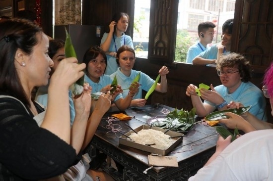 6月9日，美國青年代表在重慶永川松溉古鎮(zhèn)體驗包粽子。新華社記者 周思宇 攝