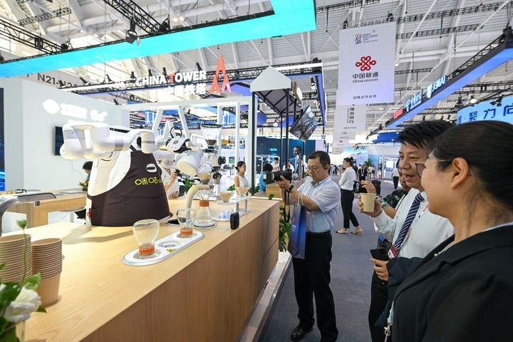 6月20日，與會者品嘗機器人沖調(diào)出的咖啡。新華社記者 孫凡越 攝