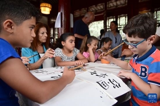 7月4日，在馬耳他桑塔露琪亞市的中國古典園林“靜園”，人們體驗中國書法。新華社發(fā)（喬納森·博格 攝）