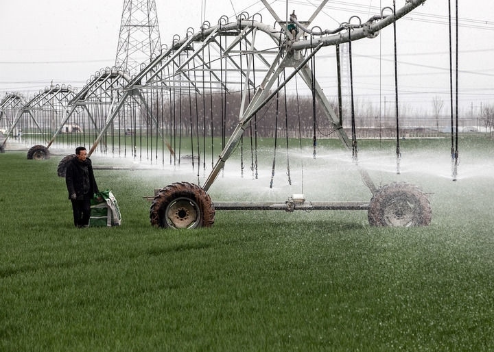 2024年3月18日，在河南省焦作市博愛(ài)縣孝敬鎮(zhèn)東原莊村瑞輝家庭農(nóng)場(chǎng)，村民使用全自動(dòng)指針式噴灌機(jī)進(jìn)行澆灌作業(yè)。新華社發(fā)（程全攝）