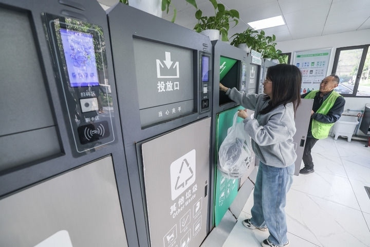 2024年4月10日，在浙江省湖州市吳興區(qū)飛英街道新華府小區(qū)內(nèi)，居民在垃圾分類智能系統(tǒng)的指導(dǎo)下進(jìn)行垃圾分類投放，居民的投放情況將實(shí)時(shí)匯總到智慧服務(wù)平臺(tái)，會(huì)有相應(yīng)的積分獎(jiǎng)勵(lì)。新華社記者 徐昱 攝