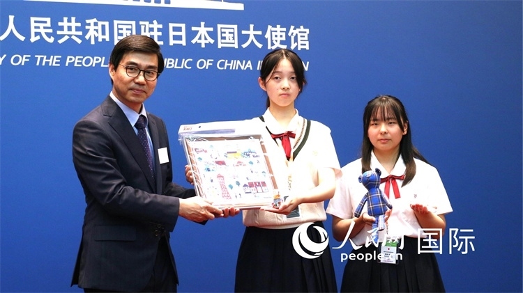 日本小大使向中國駐日本大使館臨時代辦施泳贈送當?shù)靥厣Y品。人民網(wǎng) 許可攝